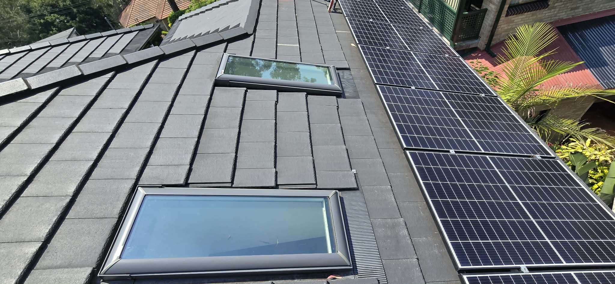 Charcoal tiled roof and twin skylights freshly washed, solar panels alongside